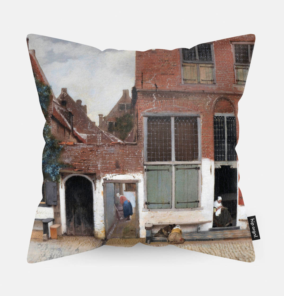Kussen met schilderij van het straatje van een huis erop afgebeeld.