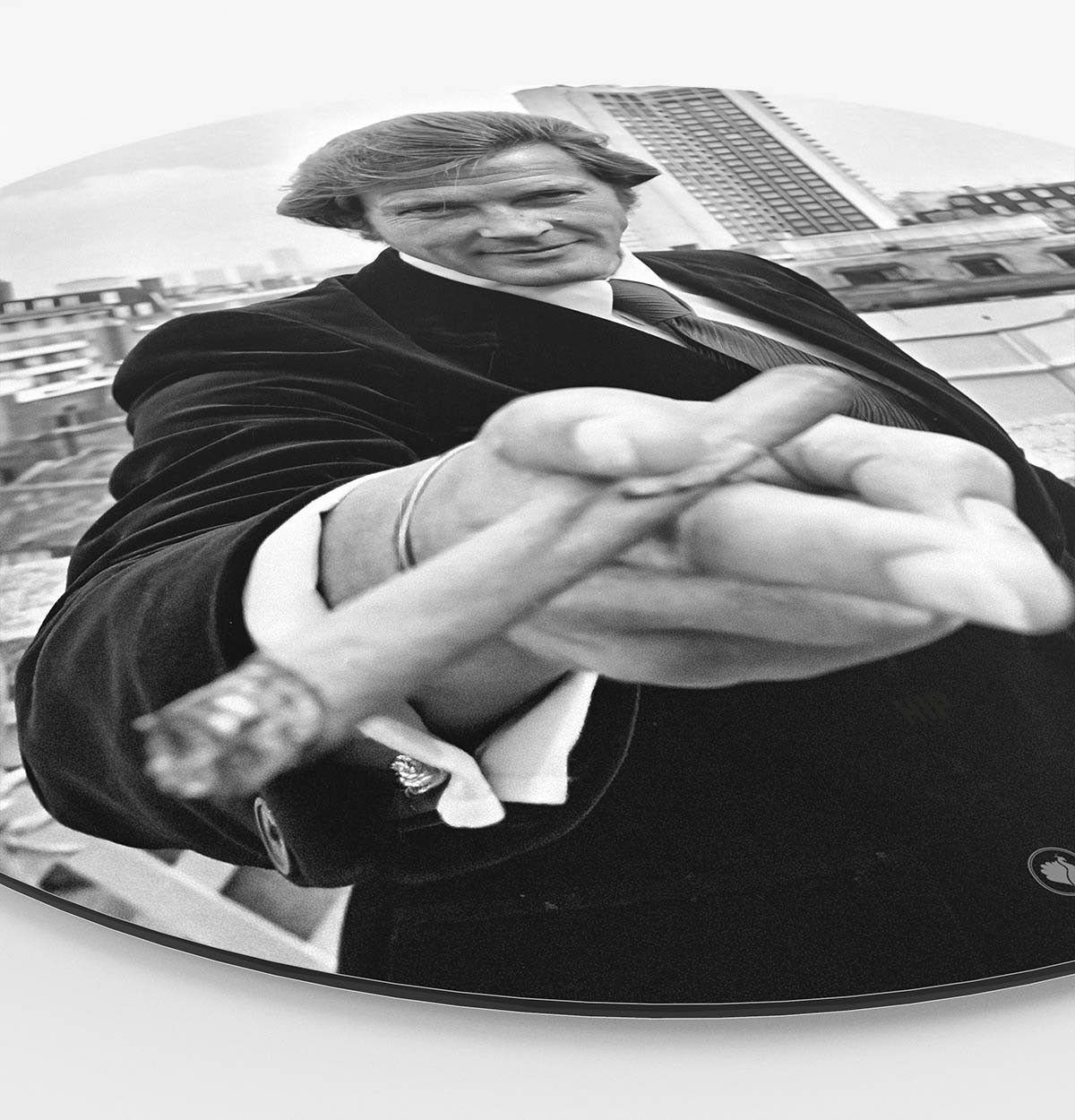 Zijkant van een wandcirkel met daarop Roger Moore met een sigaar in zijn hand