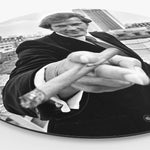 Zijkant van een wandcirkel met daarop Roger Moore met een sigaar in zijn hand