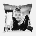 Audrey Hepburn met een sigaret in haar hand op ene kussen aan het ontbijt