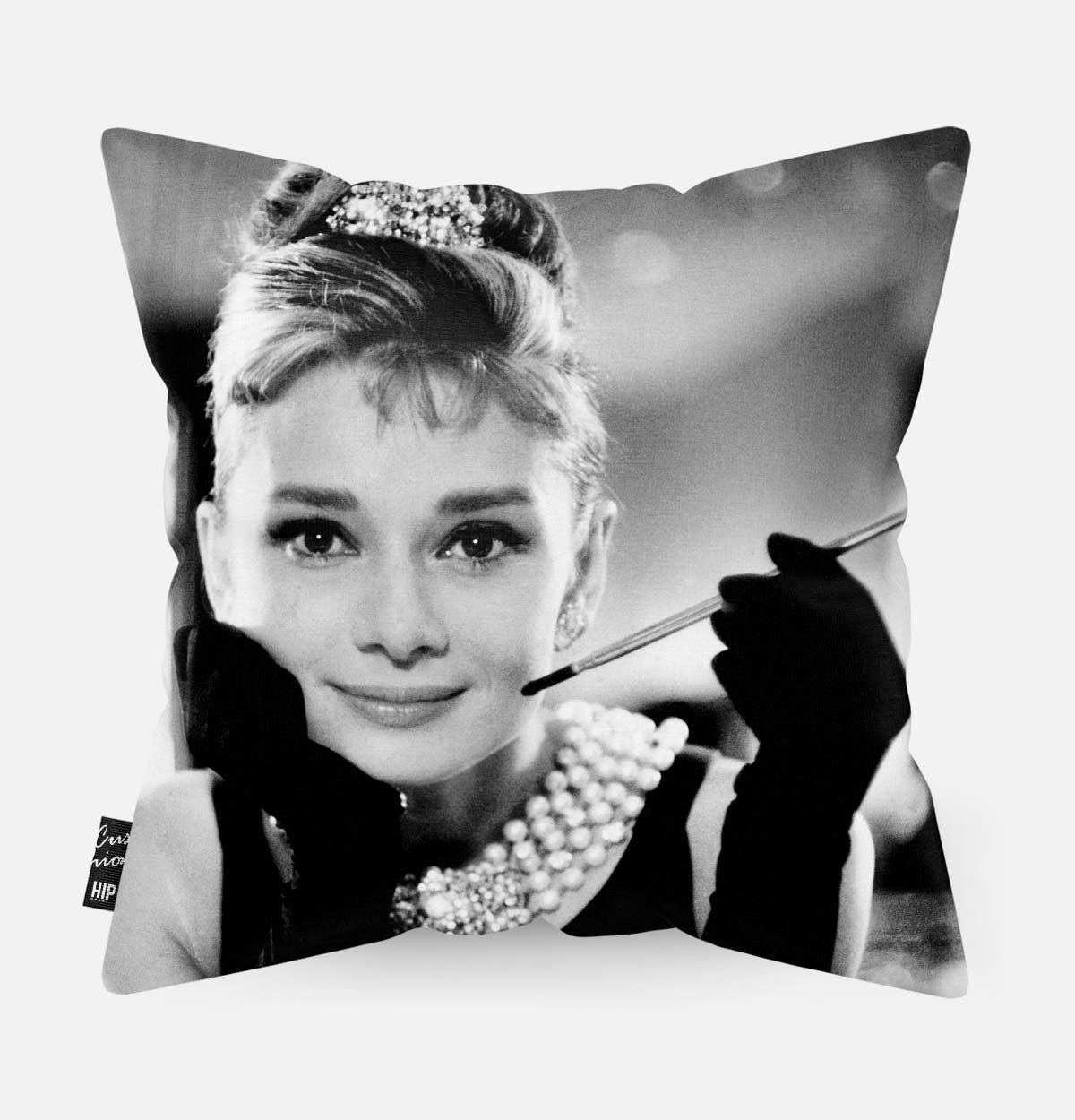 Audrey Hepburn met een sigaret in haar hand op ene kussen
