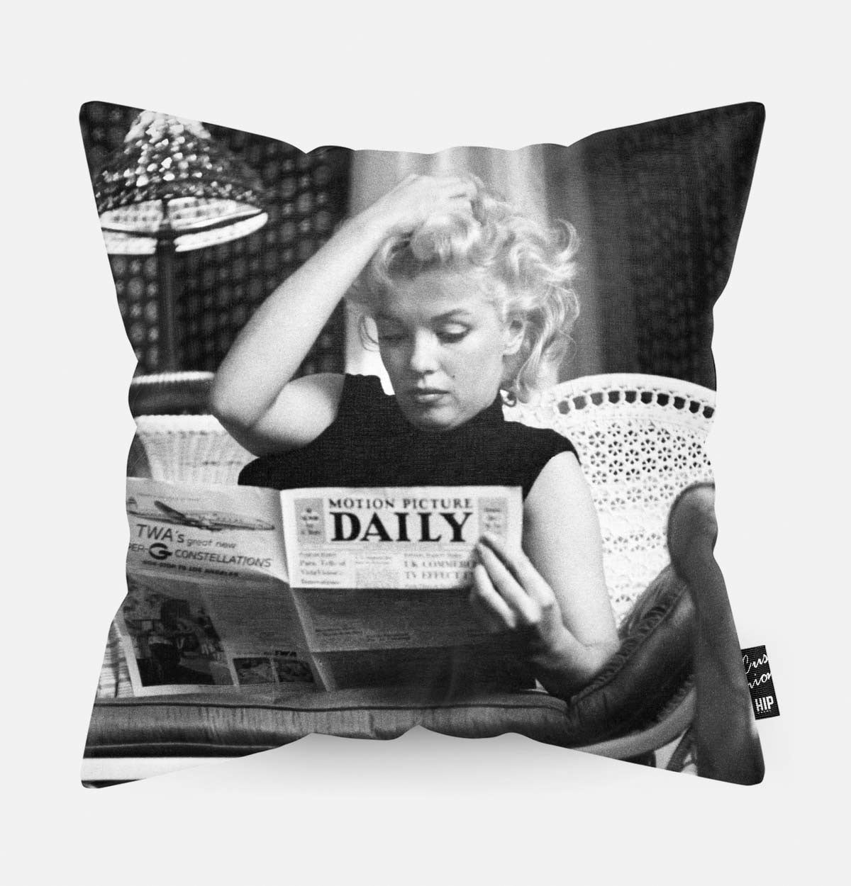 Sierkussen met daarop Marilyn Monroe die een krant leest.