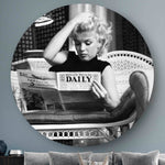Wanddecoratie aan de muur met daarop Marilyn Monroe die een krant leest