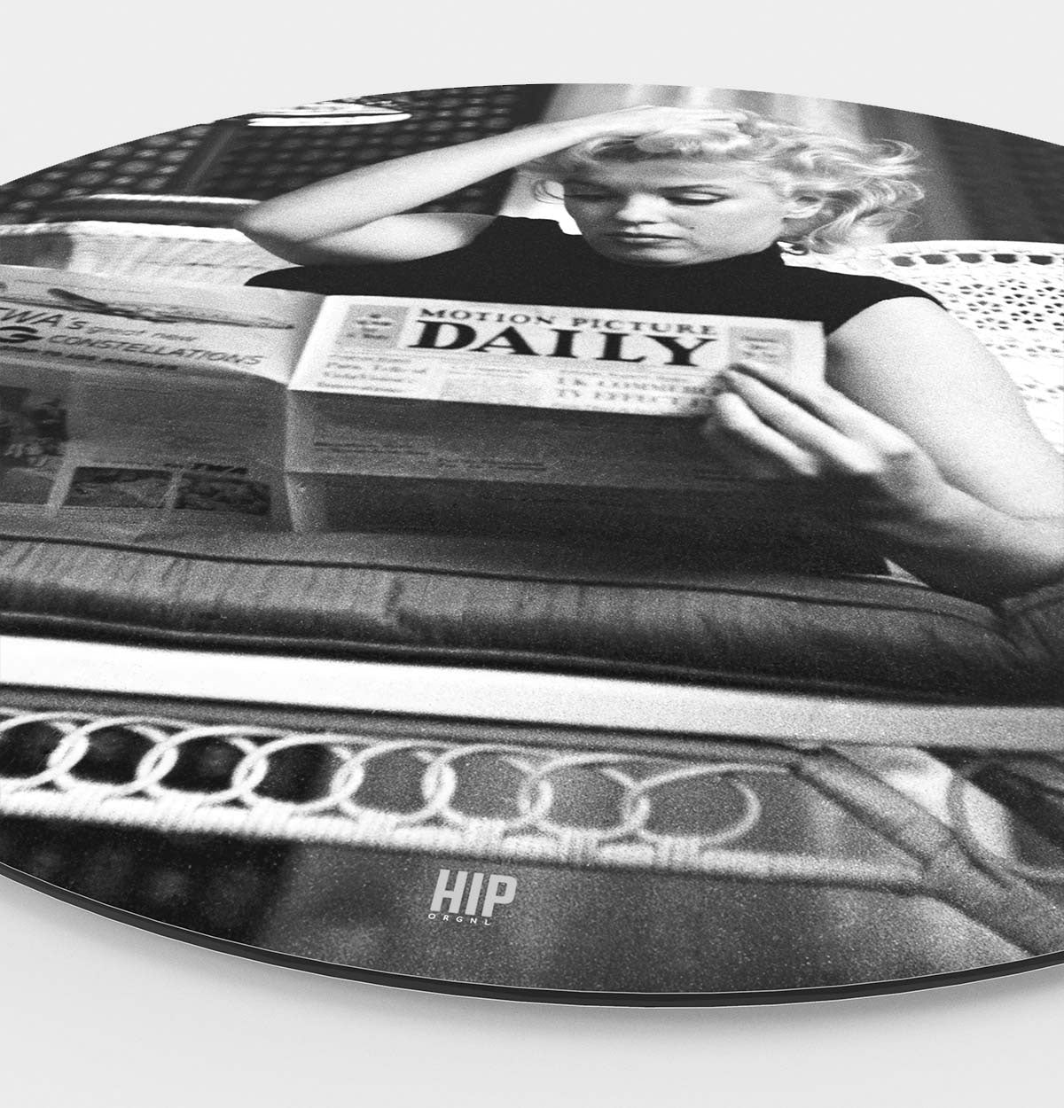 Zijkant van een wanddecoratie aan de muur met daarop Marilyn Monroe die een krant leest