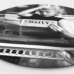 Zijkant van een wanddecoratie aan de muur met daarop Marilyn Monroe die een krant leest