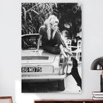 Vierkante wanddecoratie van Brigitte Bardot met een hond afgebeeld.