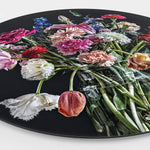 Zijkant van een wandcirkel met kleurrijke bloemen in een glazen vaas