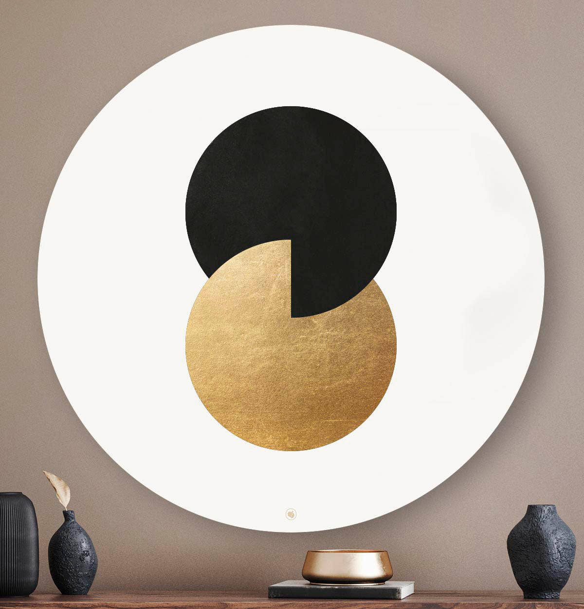 Muurcirkel met twee cirkels in het zwart en goud tegen een taupe muur