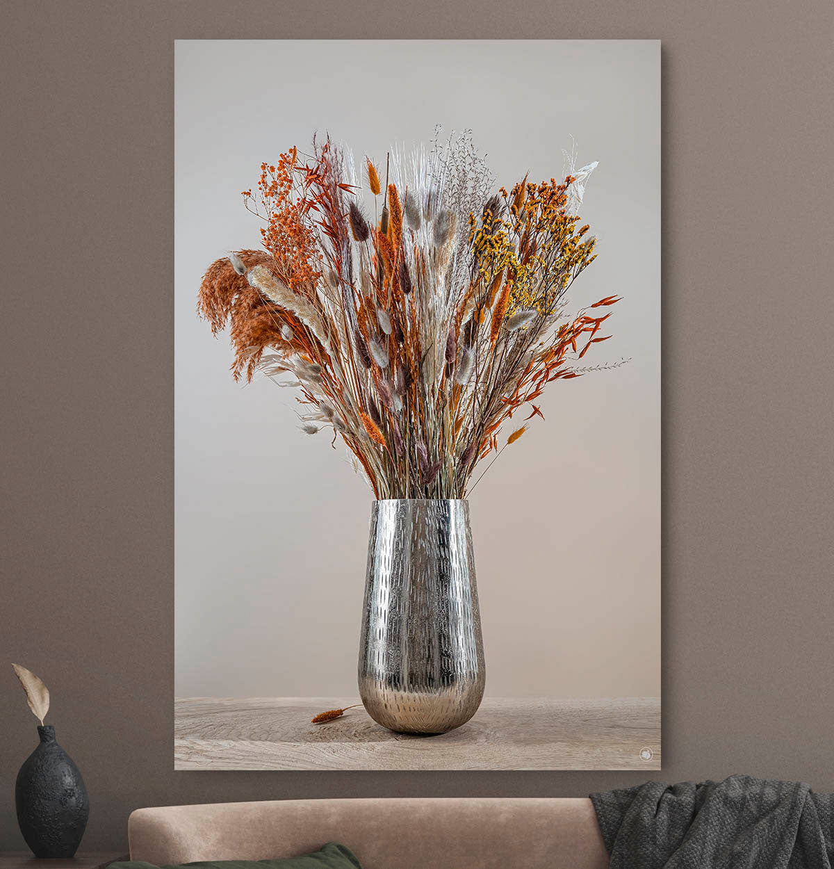 Schilderij met droogbloemen met koper kleur tegen een muur