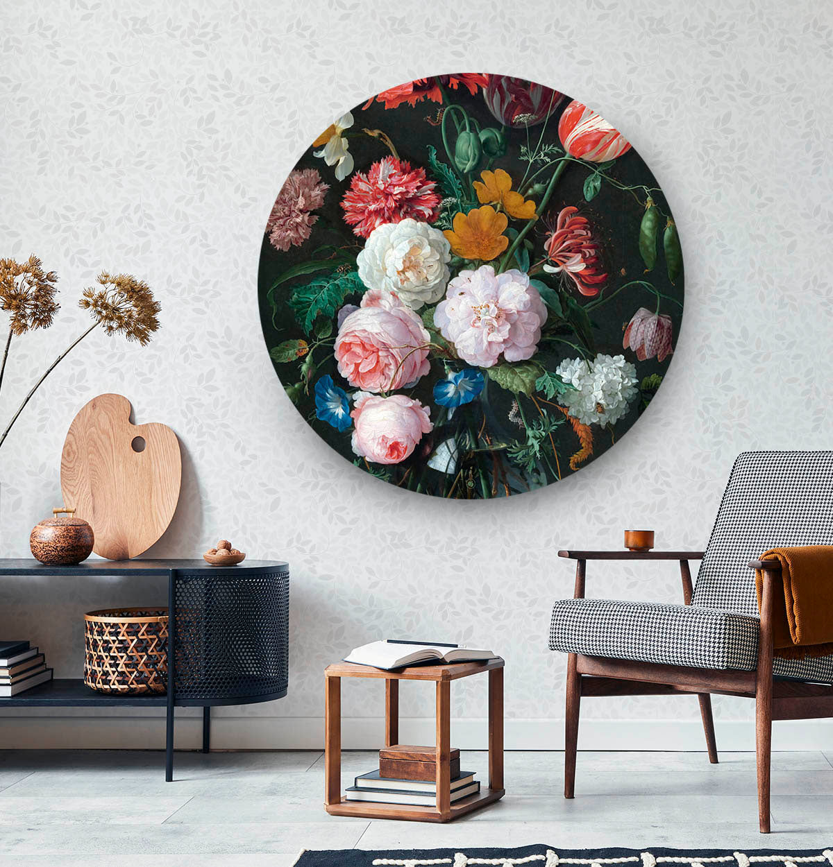 Wandcirkel met bloemen tegen een witte muur met een zwart dressoir en een houten stoel