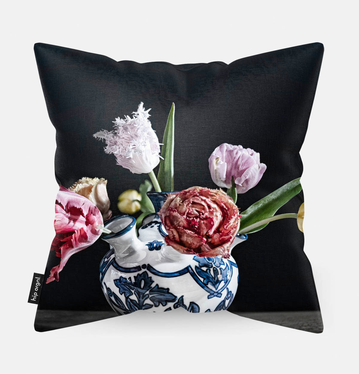 Achterzijde van een sierkussen met een vaas met tulpen met een donkere achtergrond in Delfts blauwe vaas