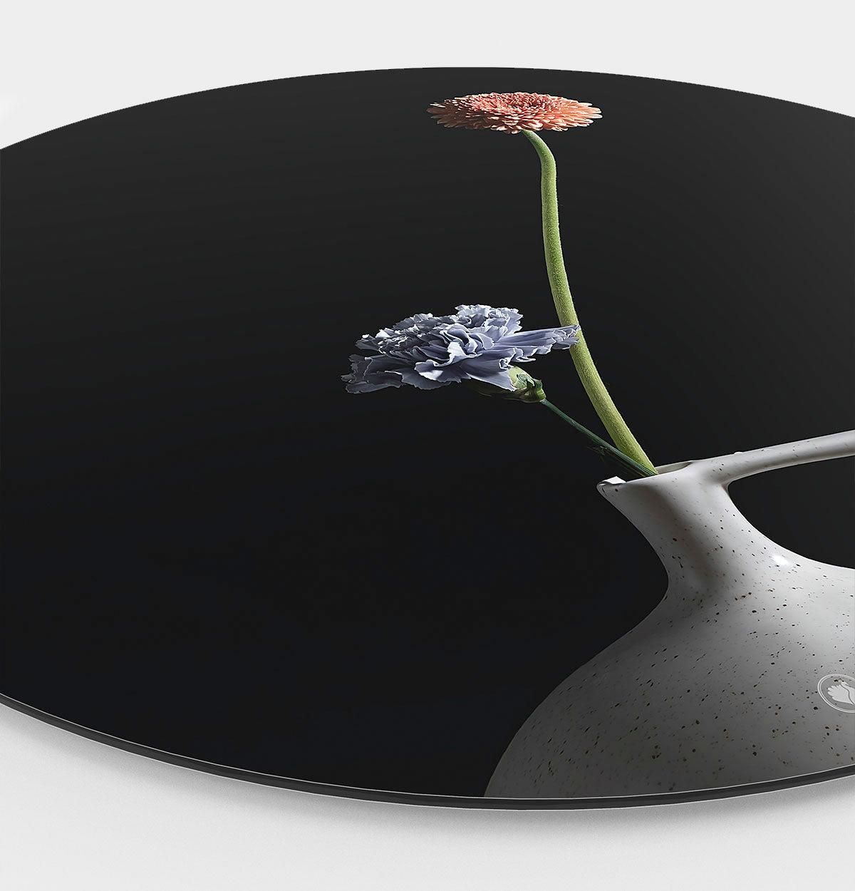 Muurcirkel met een wit vaasje met twee bloemen een donkere achtergrond