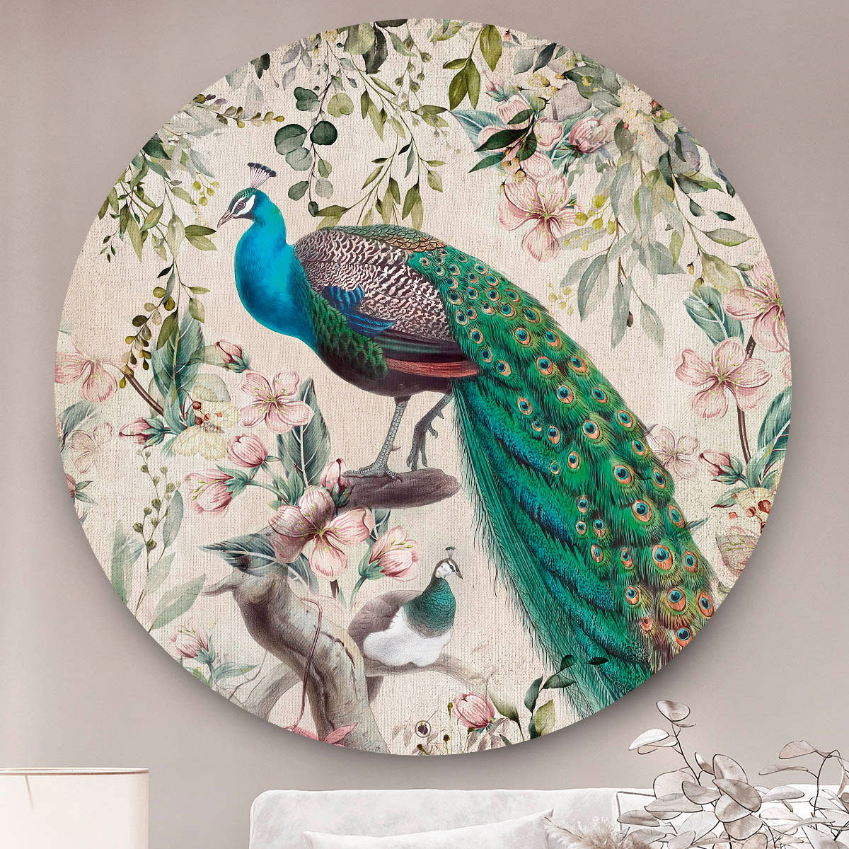 Wandcirkel met pauwen met een groene staart en roze bloemen tegen een beige muur