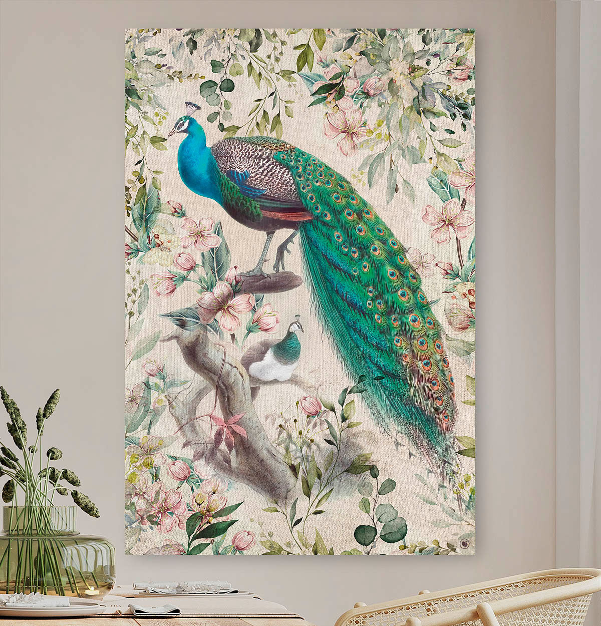 Schilderij met pauwen met een groene staart en roze bloemen tegen een beige muur en een stoel