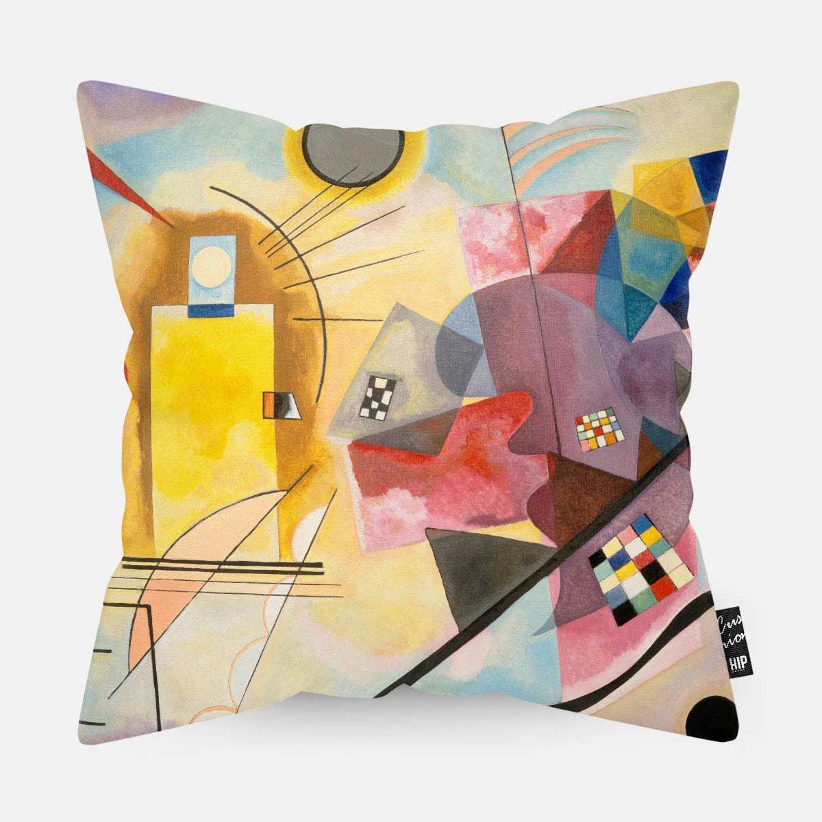 Kussen met moderne kunst en de kleuren geel, rood, blauw erop afgebeeld.