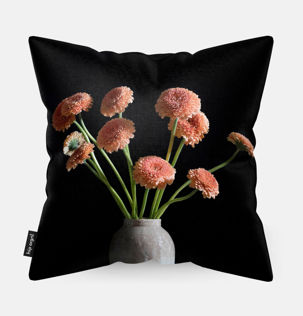 Achterzijde van een sierkussen met gerbera's in een grijze vaas met een zwarte achtergrond