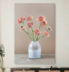 Schilderij met gerbera's en een grijze vaas tegen ene lichte muur en een japandi dressoir