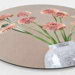 Zijkant van een wandcirkel met gerbera's en een grijze vaas