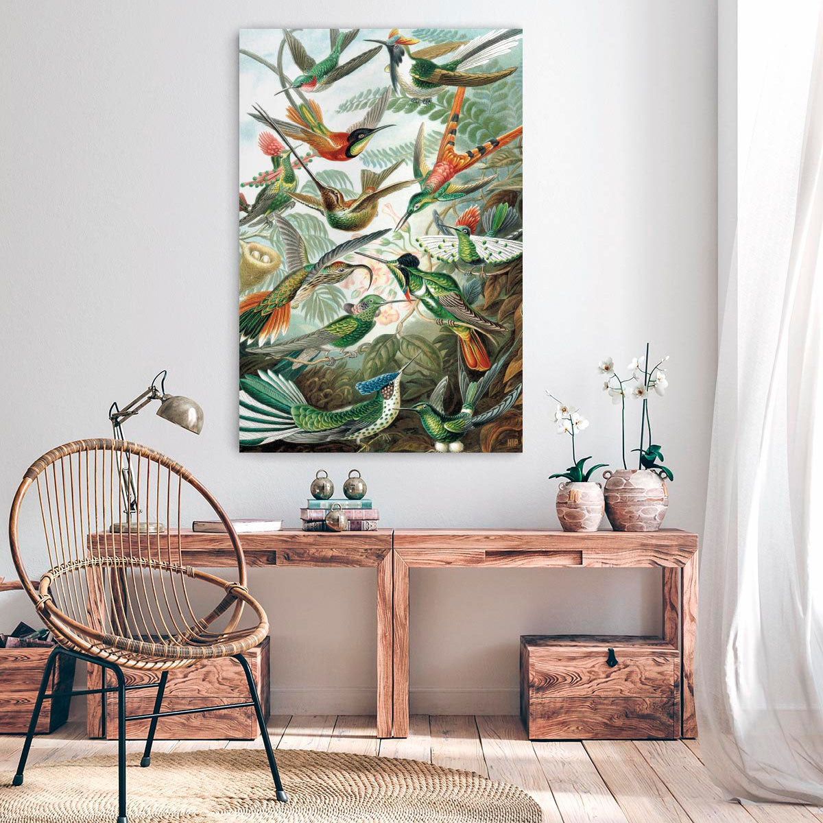 Woonkamer met houten tafel met daarboven een vierkante wanddecoratie met daarop verschillende vogels op afgebeeld.