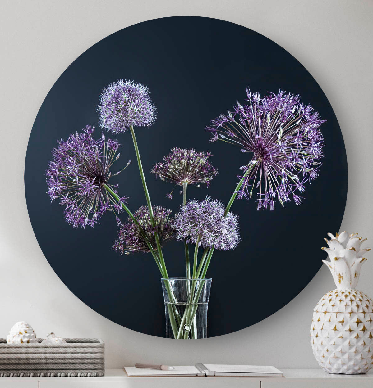 Muurcirkel met paarse bloemen en een zwarte achtergrond tegen een muur met een witte ananas