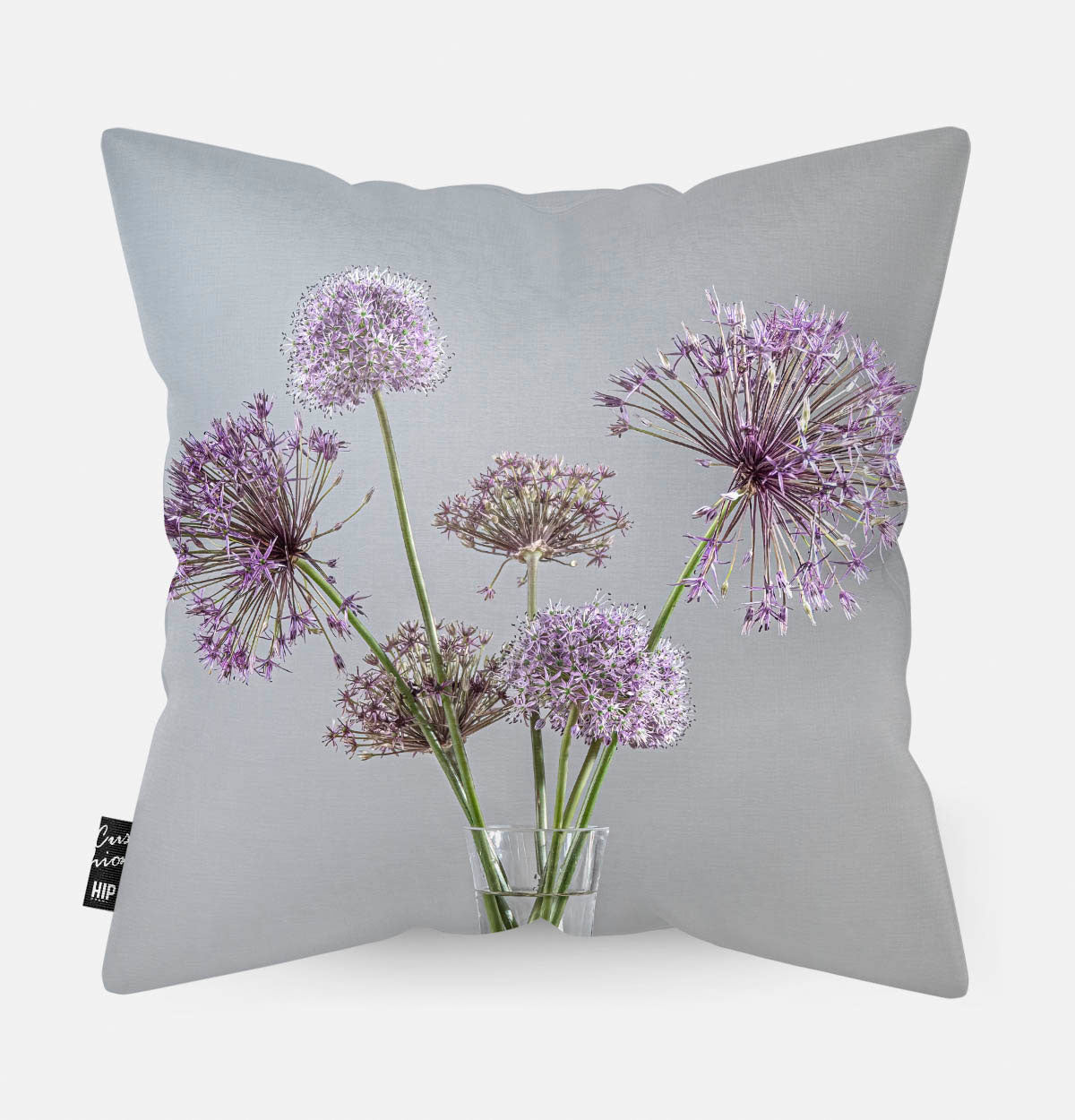 Achterzijde van een sierkussen met paarse bloemen en een lichte achtergrond