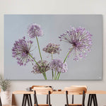Schilderij met paarse bloemen en een grijze achtergrond en nbeige eetkamerstoelen en tafel