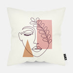 Kussen met line art met vrouwengezicht en verschillende roze en oranje figuren erop afgebeeld.