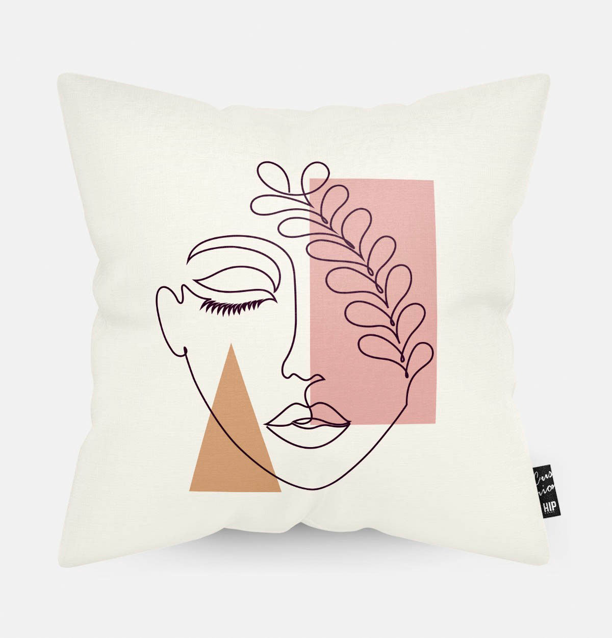 Kussen met line art met vrouwengezicht en verschillende roze en oranje figuren erop afgebeeld.