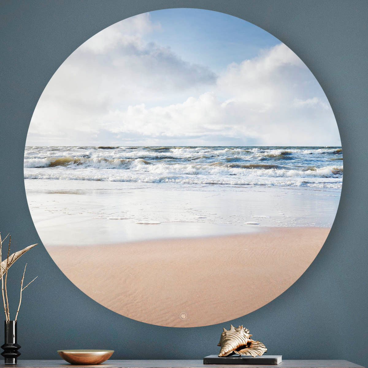 Wandcirkel met strand en zee tegen een blauwe muur