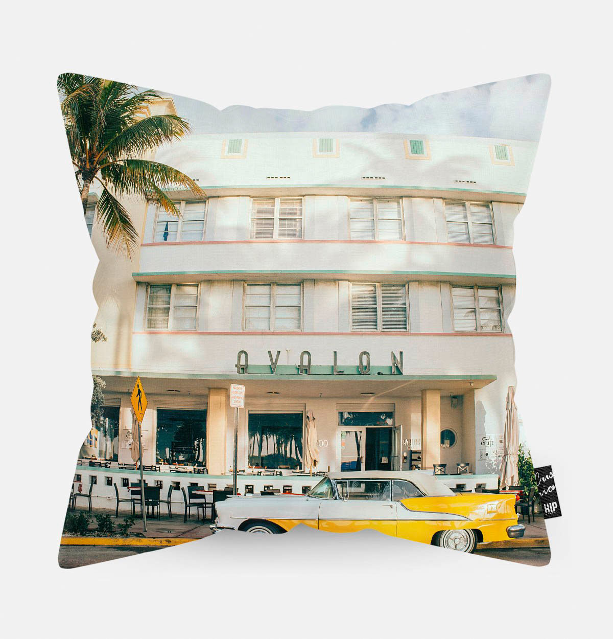 Kussen met een gele luxe auto voor een hotel erop.