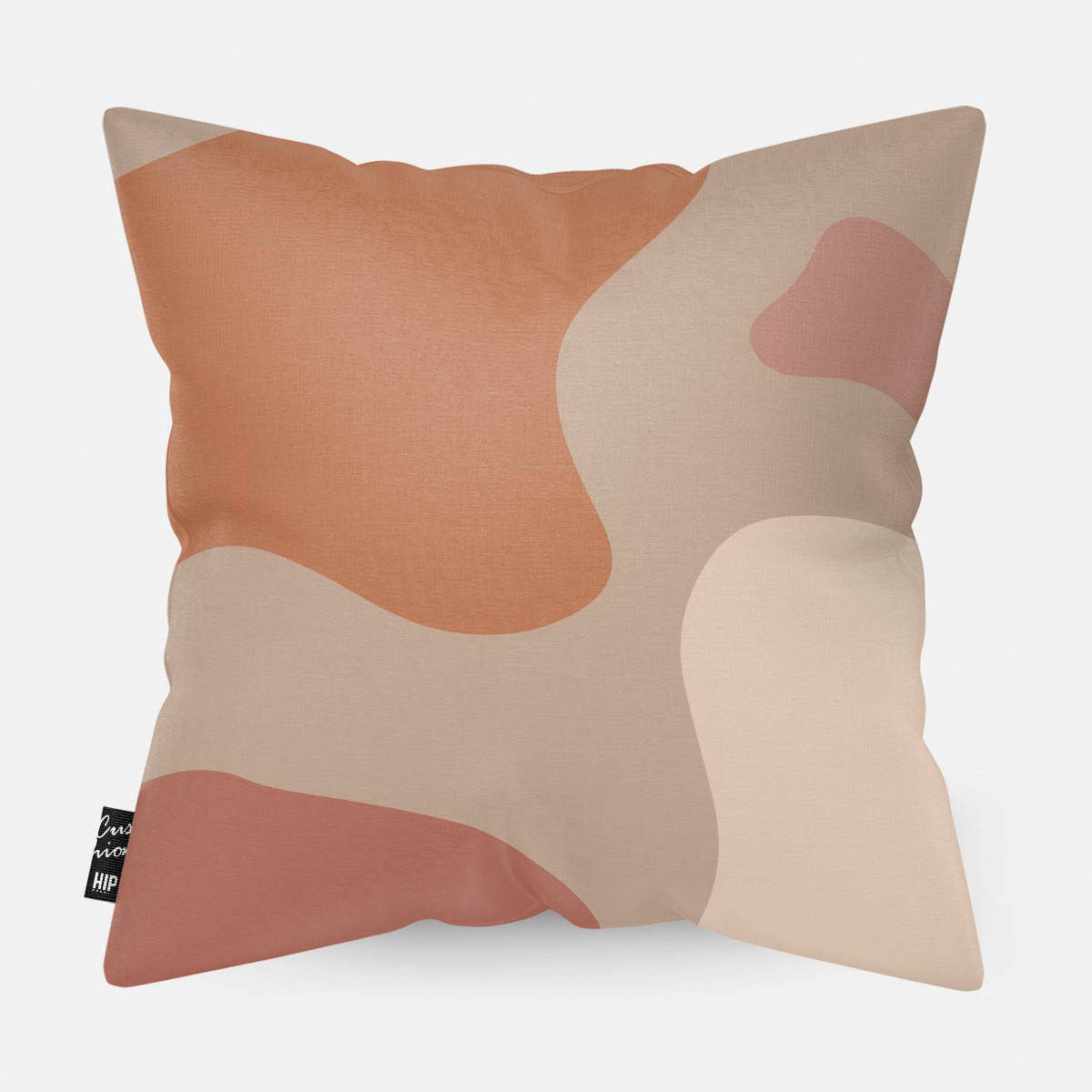 Kussen met line art met verschillende roze en oranje vierkanten erop afgebeeld.