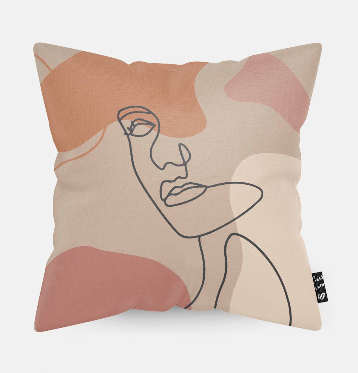 Kussen met line art met vrouwengezicht en verschillende roze vierkanten erop afgebeeld.