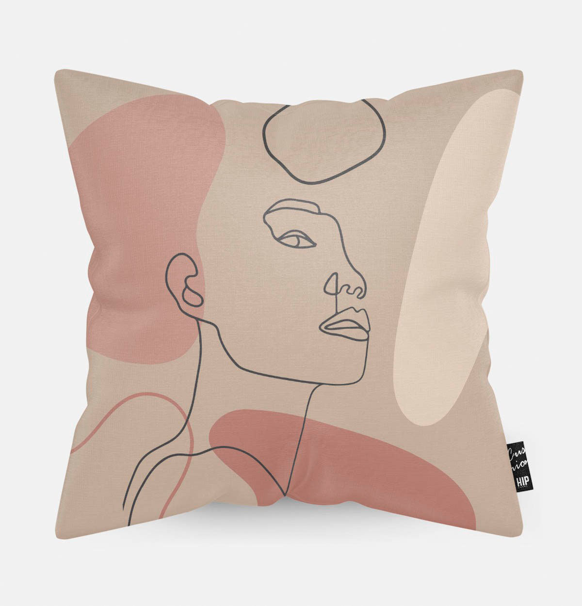 Kussen met line art met vrouwengezicht en verschillende roze vierkanten erop afgebeeld.
