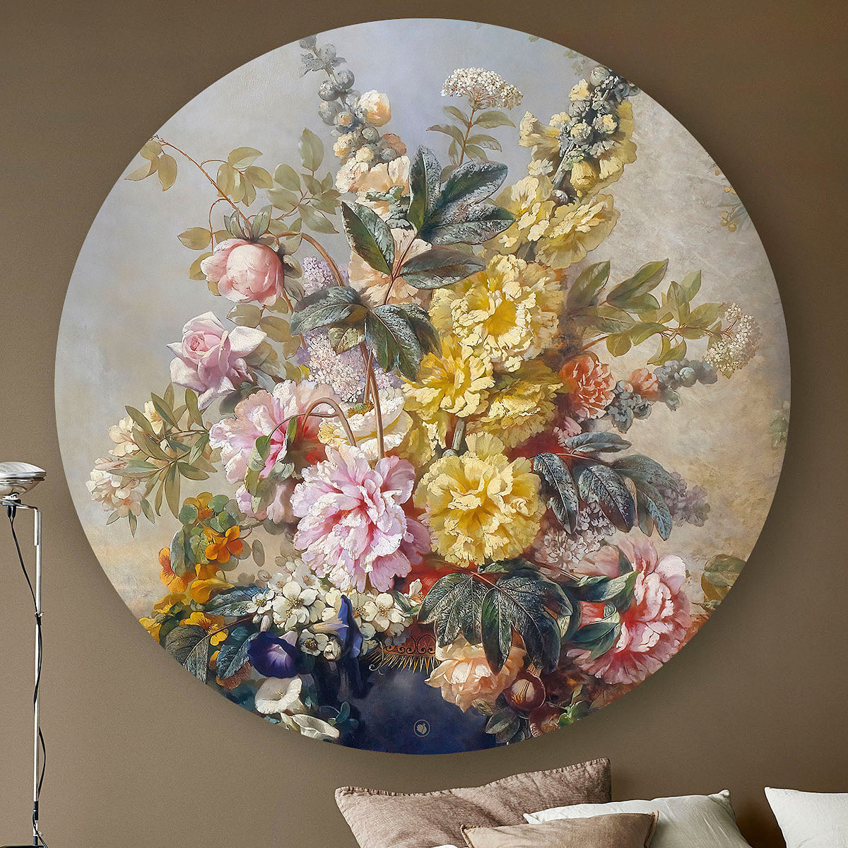 Wandcirkel met gele en roze bloemen tegen een beige muur met een lamp
