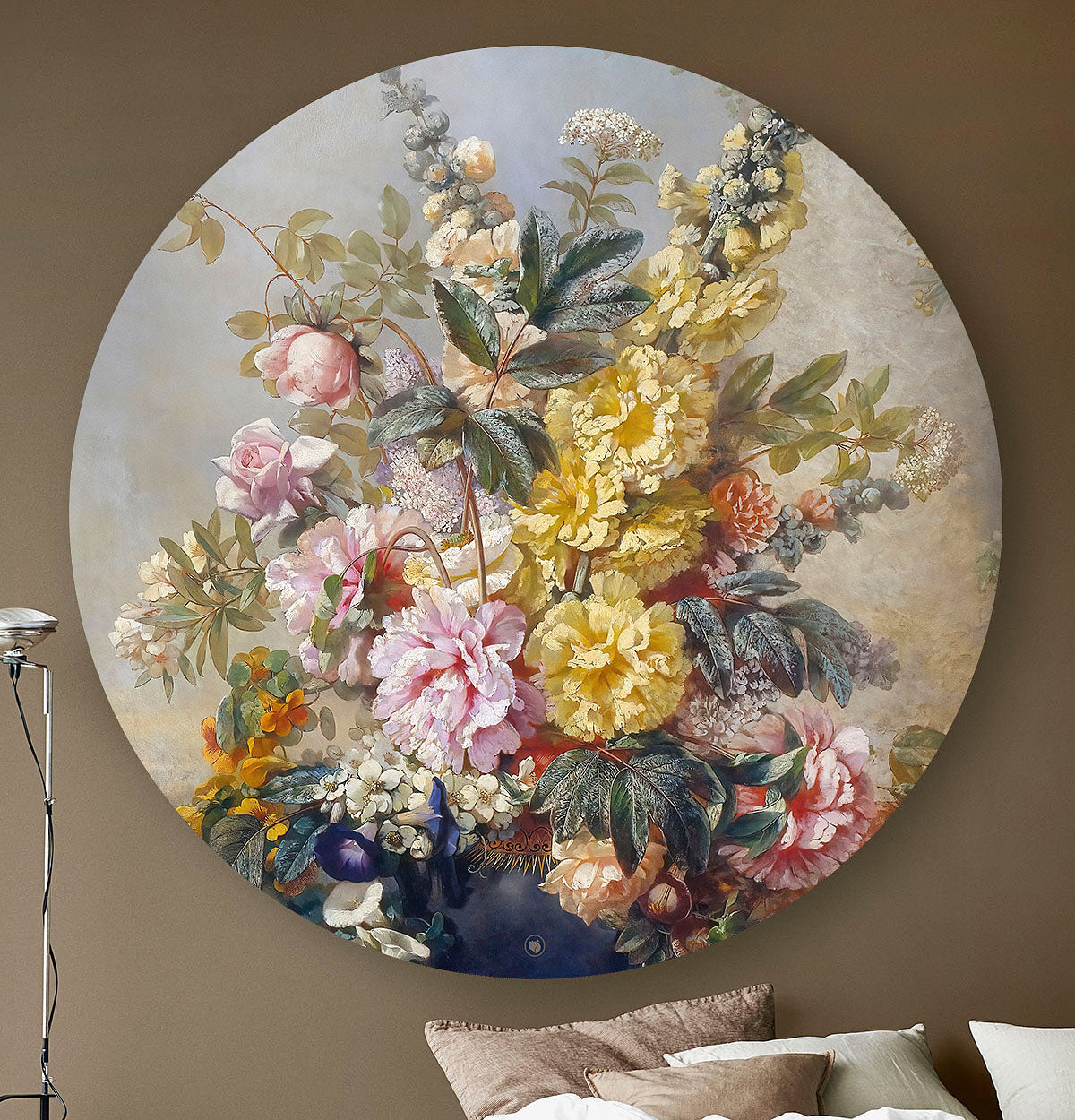 Wandcirkel met gele en roze bloemen tegen een beige muur met een lamp