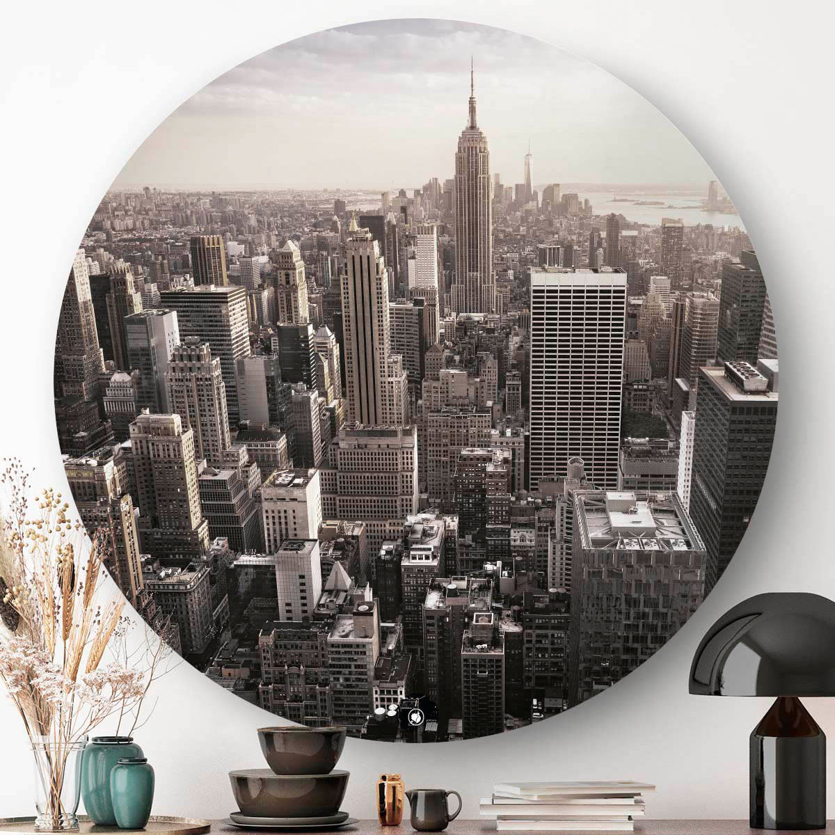 Wanddecoratie boven een dressoir met een zwarte lamp.