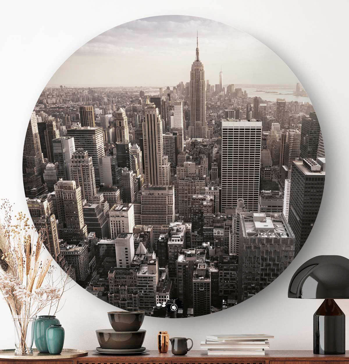 Wanddecoratie boven een dressoir met een zwarte lamp.