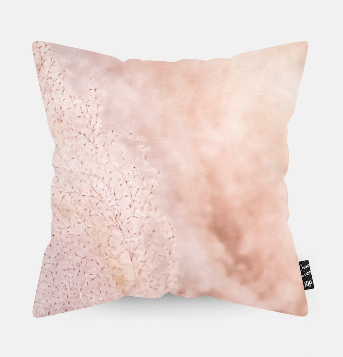 Kussen met roze pampas gras erop afgebeeld.