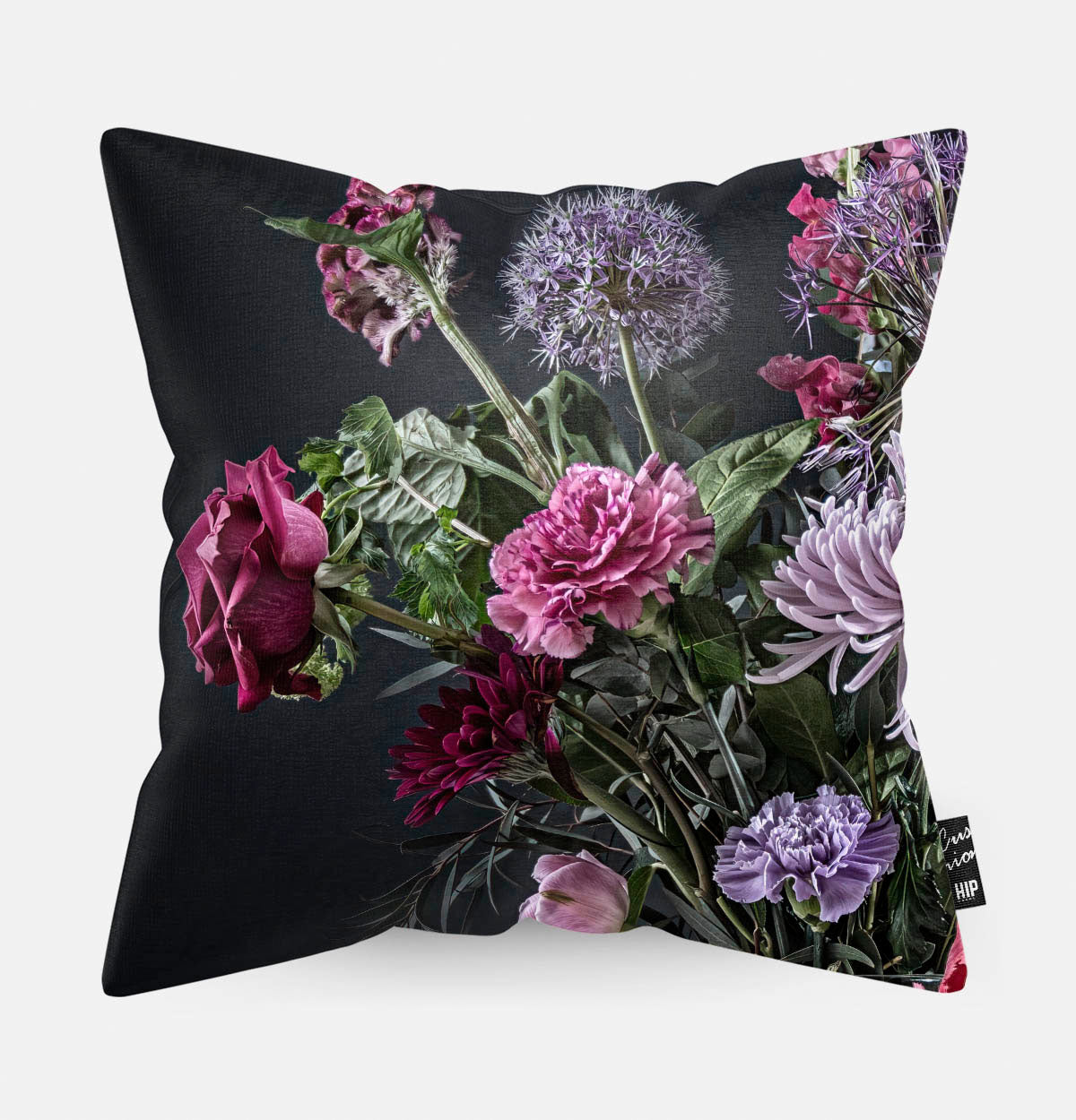Voorzijde van een sierkussen met rode en paarse bloemen met een zwarte achtergrond