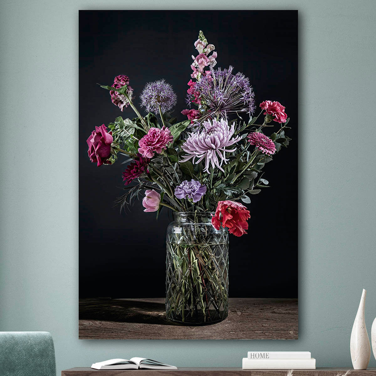 Schilderij met kleurrijke bloemen in een glazen vaas tegen een zacht groenemuur