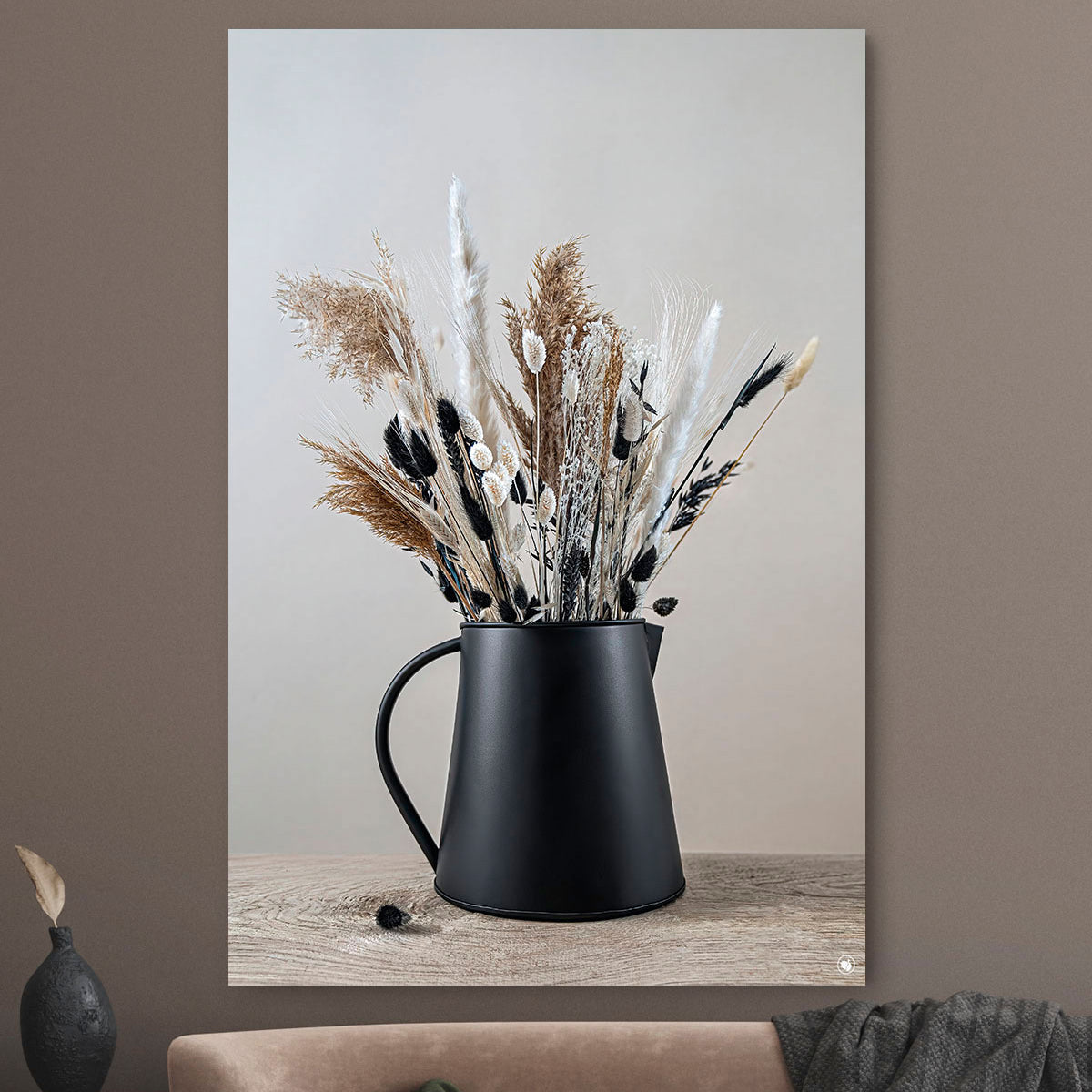 Schilderij met droogbloemen in zwart en beige tegen een beige muur