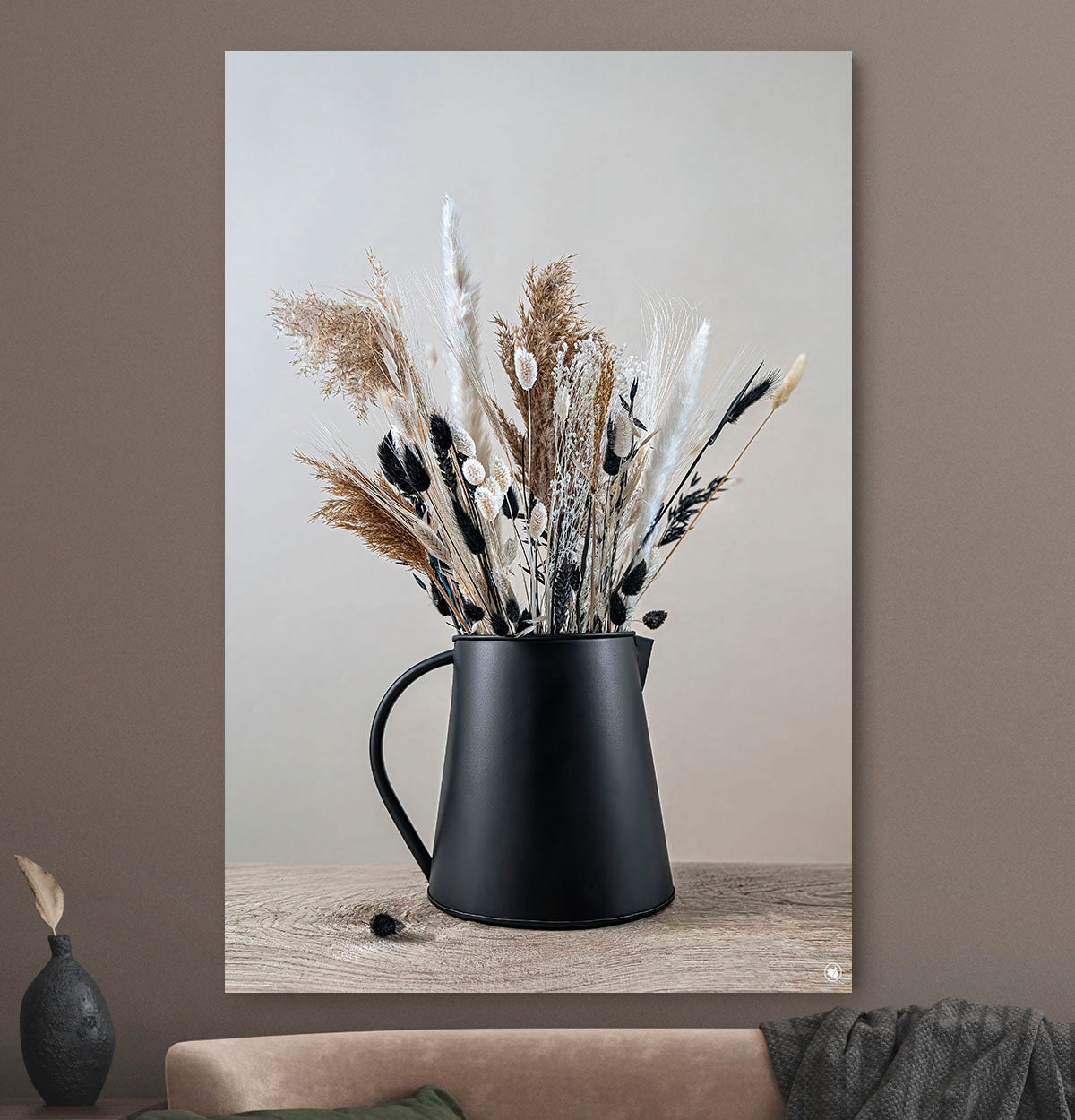 Schilderij met droogbloemen in zwart en beige tegen een beige muur