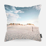 Sierkussen met strand, duinen en blauwe lucht erop