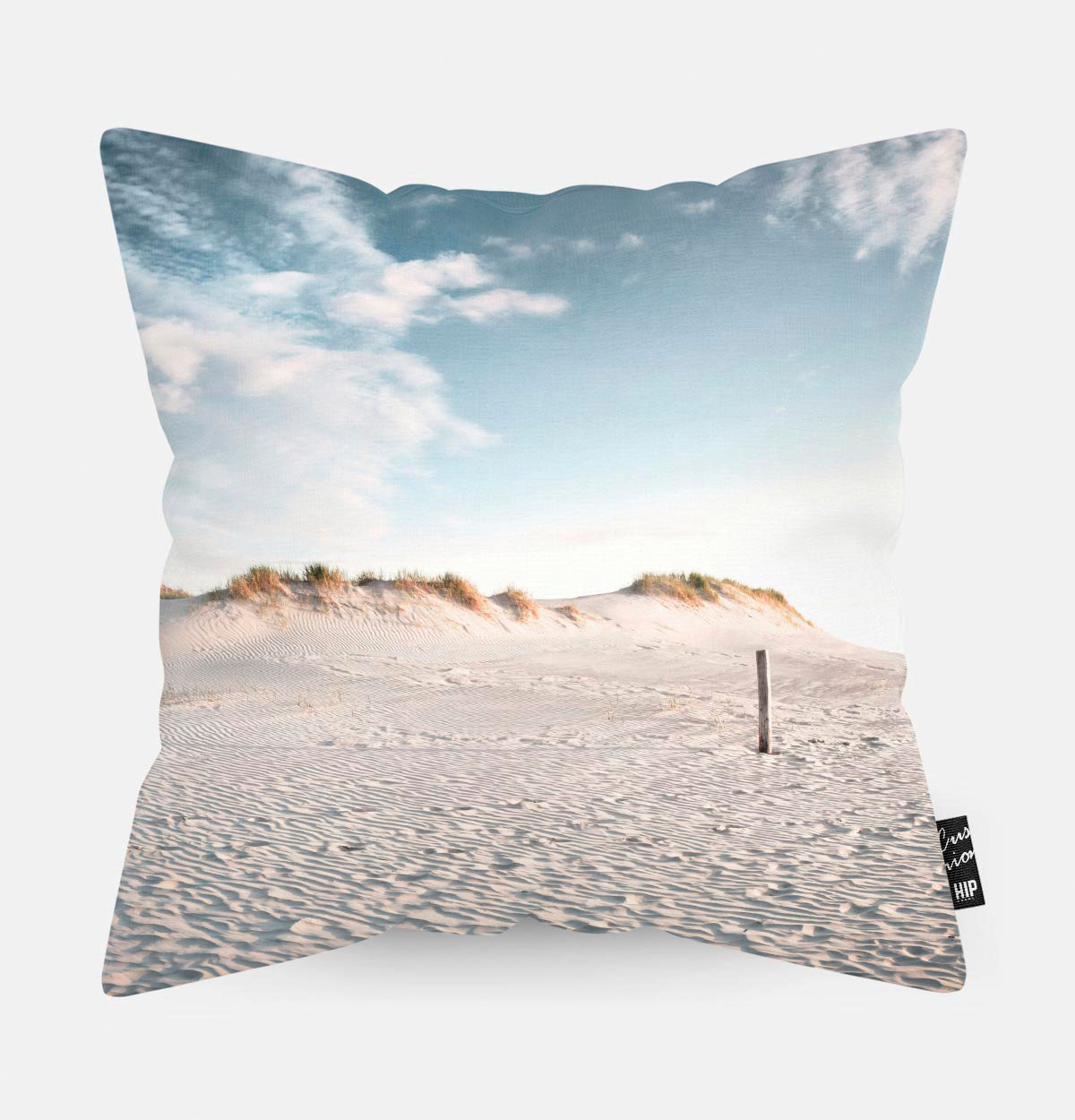 Sierkussen met strand, duinen en blauwe lucht erop