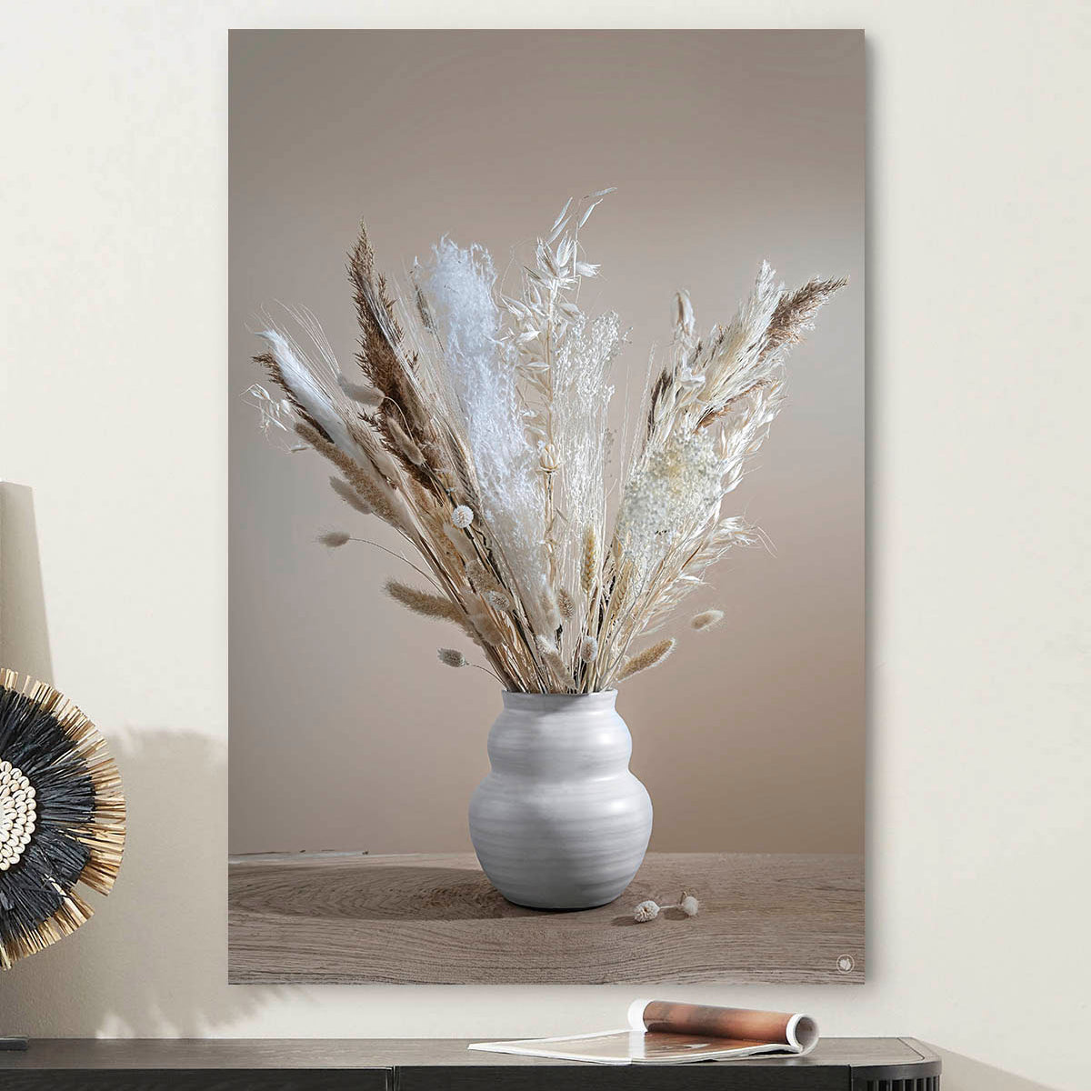 Wanddecoratie met droogbloemen en pluimen tegen een lichte muur