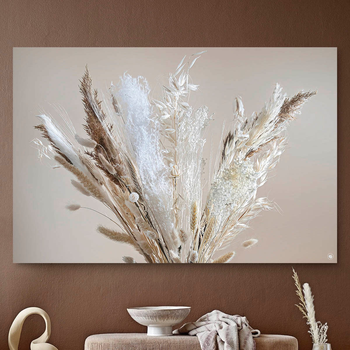 Wanddecoratie met droogbloemen en pluimen tegen een lichte muur