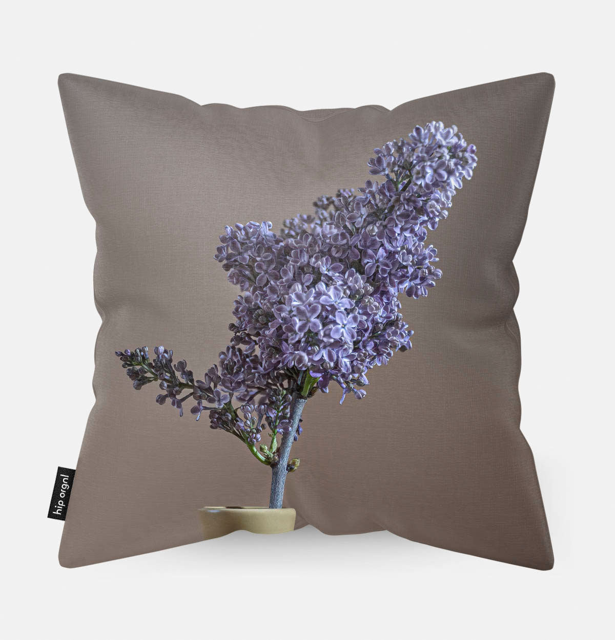 Achterzijde van sierkussen met paarse bloemen erop en een beige achtergrond