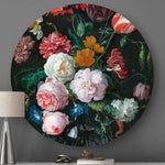 Wandcirkel met bloemen tegen een grijze muur met een lamp en een witte kap ervoor