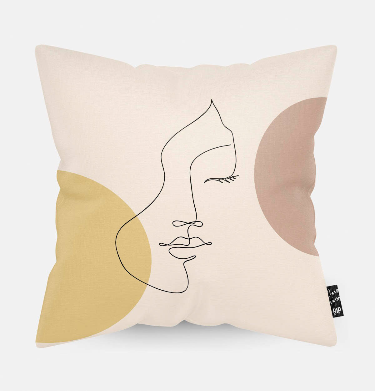 Kussen met line art met subtiele vrouwengezicht erop en twee cirkels erop.