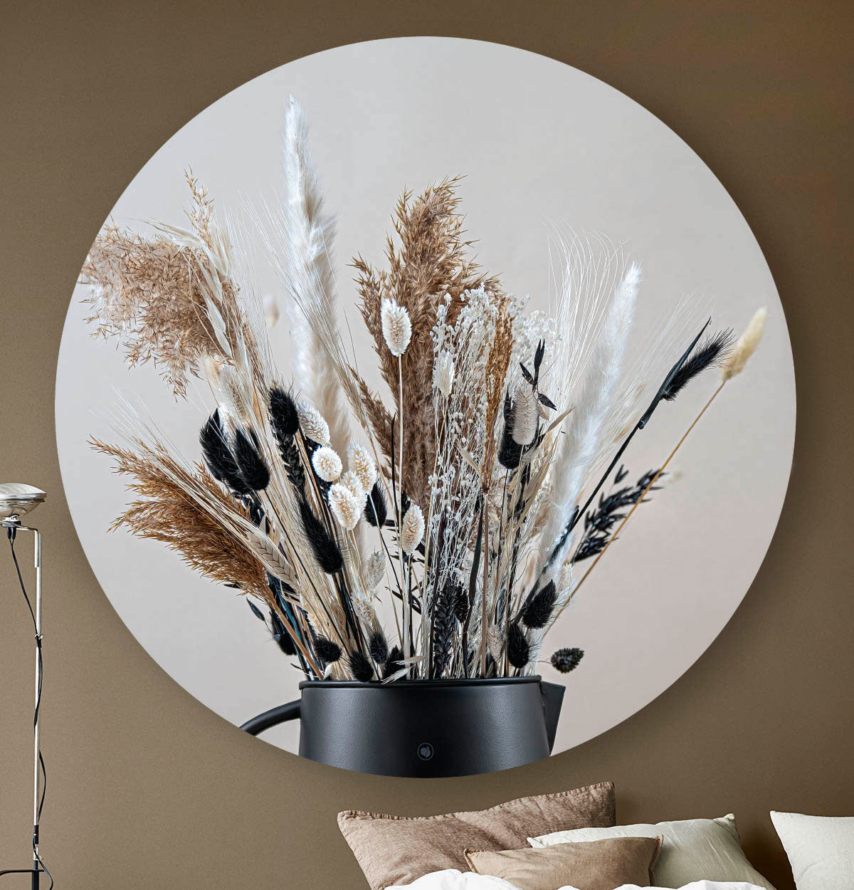 Wandcirkel met droogbloemen in zwart en beige tegen een beige muur